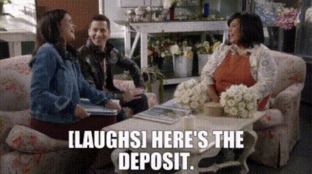 a group of people are sitting on a couch in a room with flowers on the table .