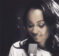 a woman is sitting in front of a microphone and smiling .