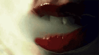a close up of a woman 's mouth with red lipstick .