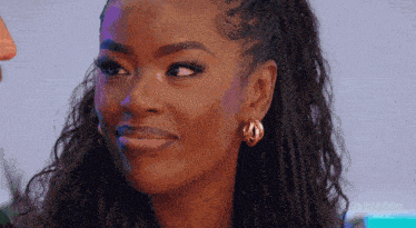 a close up of a woman 's face with braids and earrings