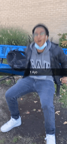 a man wearing a gap sweatshirt is sitting on a bench
