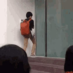 a man with an orange backpack is walking down the stairs