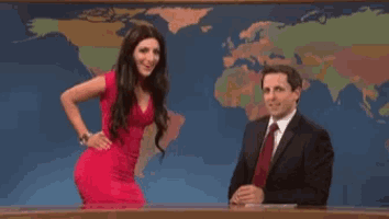 a woman in a red dress is standing next to a man in a suit and tie in front of a map of the world