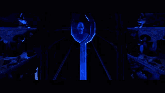a man in a blue suit is standing in a dark room with his eyes closed