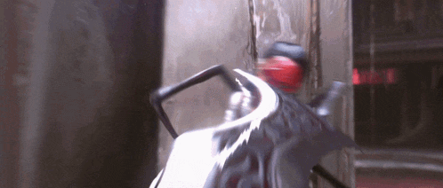 a blurred image of a person riding a motorcycle with a red sign in the background that says ' exit '