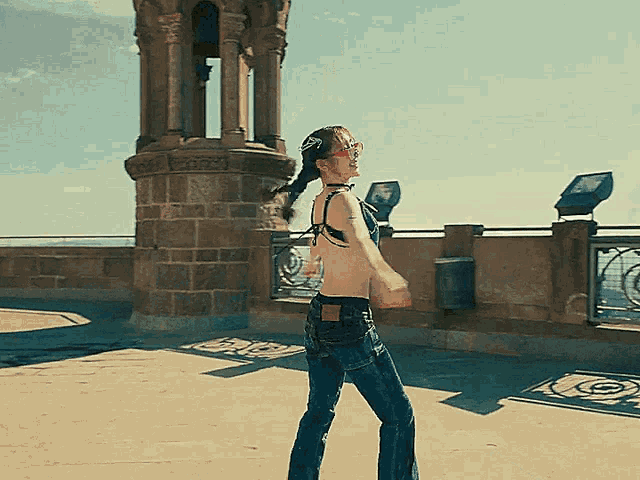 a woman without a shirt is standing in front of a large brick building
