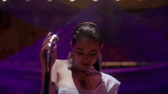 a woman singing into a microphone on a stage