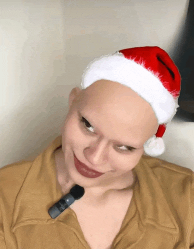 a bald woman is wearing a santa hat