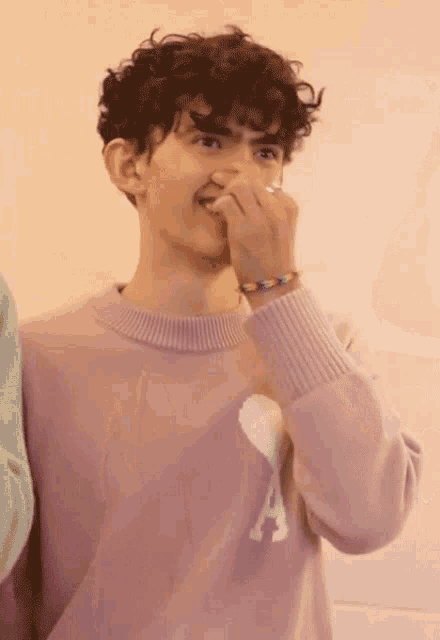 a young man wearing a purple sweater with the letter a on it
