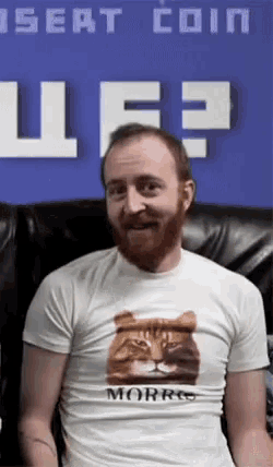a man wearing a shirt that says morris is sitting in a chair