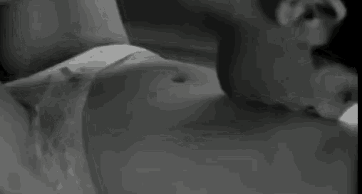 a black and white photo of a woman laying on a man 's lap .