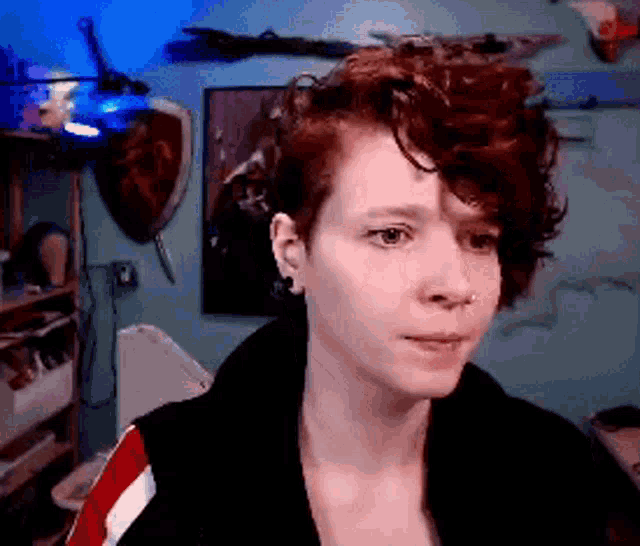 a woman with curly hair is looking at the camera