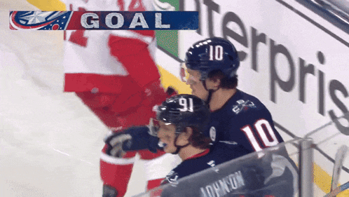 a hockey player wearing a number 10 jersey stands next to another player