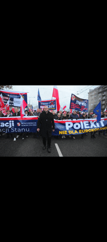 a man in a black coat holds a sign that says polex