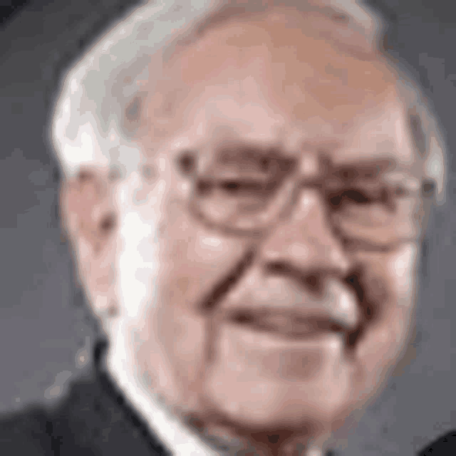 a close up of a man wearing glasses and a suit smiling .