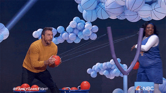 a man and a woman are playing a game called family game fight on nbc