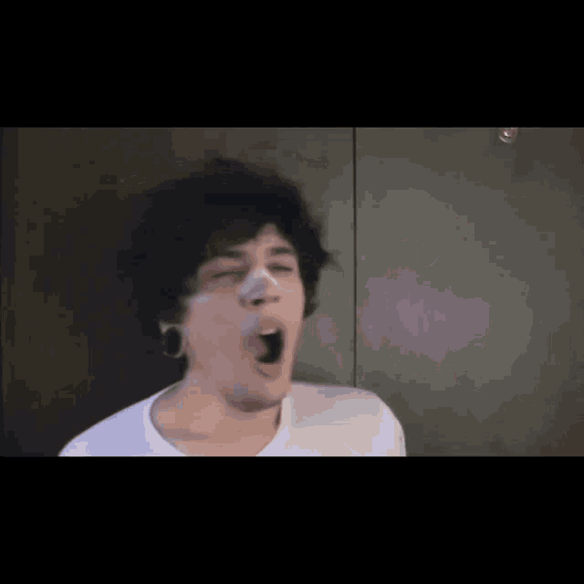 a man with a bandage on his nose is yawning with his mouth open