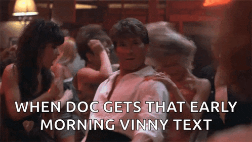 a man is sitting in a crowd of people with the words when doc gets that early morning vinny text below him .