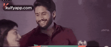 a man and a woman are smiling and looking at each other