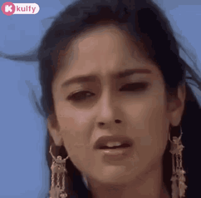 a close up of a woman 's face with a blue sky in the background .