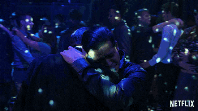 two men hugging in a crowd with netflix written on the bottom