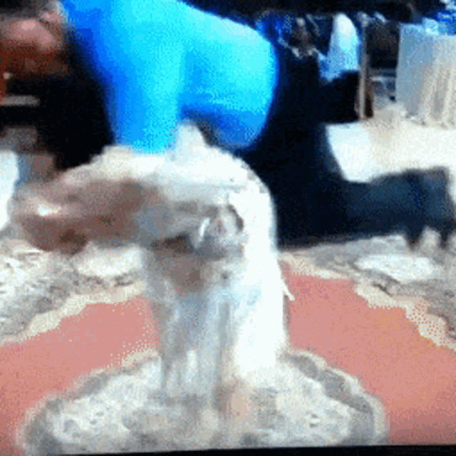 a man in a blue shirt is kneeling down next to a dog on a rug