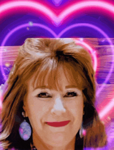 a woman is smiling in front of a pink heart