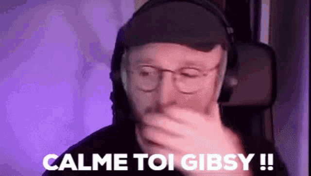 a man wearing glasses and headphones is covering his mouth with his hand and says calme toi gibsy !!