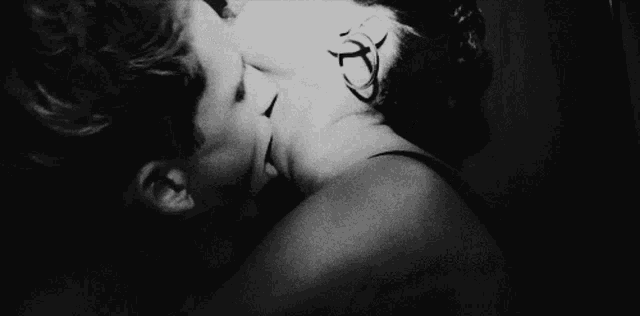 a black and white photo of a person touching a woman 's shoulder with a tattoo that says hope