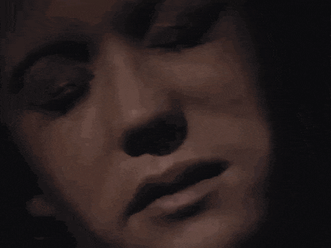 a close up of a woman 's face with her eyes closed in a black and white photo .