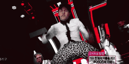 a man in a white shirt and leopard print pants is dancing on a stage ..