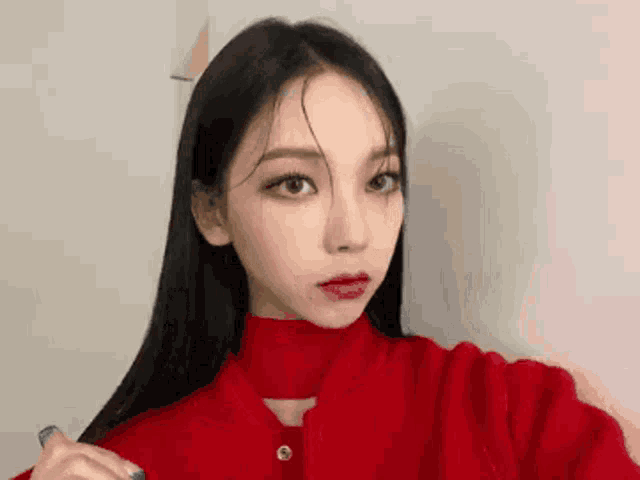 a close up of a woman taking a selfie in a red sweater .