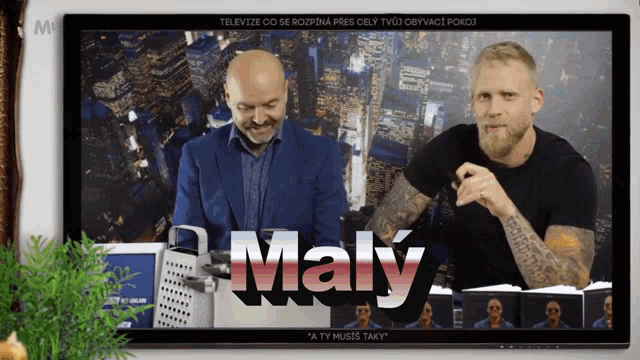 two men sitting in front of a screen that says maly on it