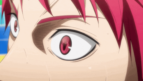 a close up of a person 's eyes with red hair
