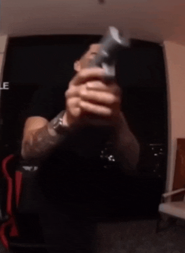 a man is laughing while holding a remote control in his hand