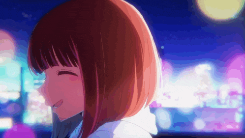 a close up of a girl with short hair smiling in front of a city at night .