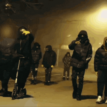 a group of people wearing face masks are walking down a street