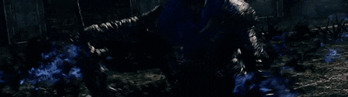 a close up of a person holding a sword in a dark room .