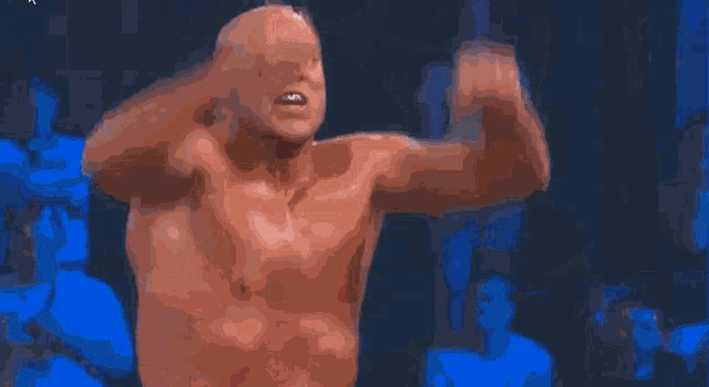 a wrestler in a ring with a referee and a crowd behind him that says wwe