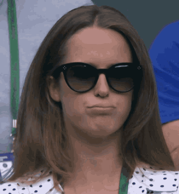 a woman wearing sunglasses makes a funny face with her mouth open