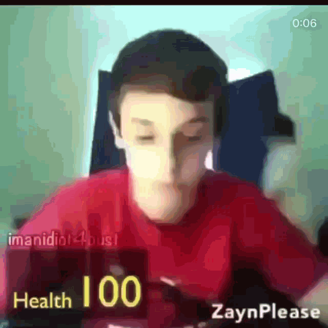 a man in a red shirt is sitting in front of a screen that says " health 100 "