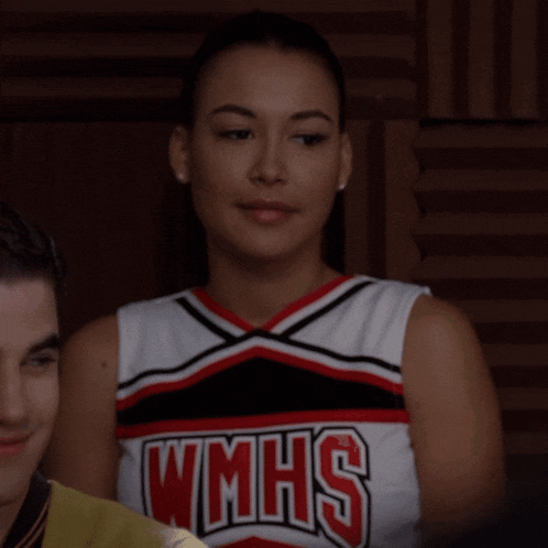 a woman wearing a wmhs cheerleader uniform looks down