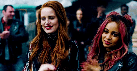 two women with red hair are standing next to each other and smiling .
