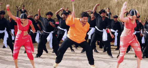 a group of people are dancing in a field and one of them is wearing a shirt that says ' a ' on it