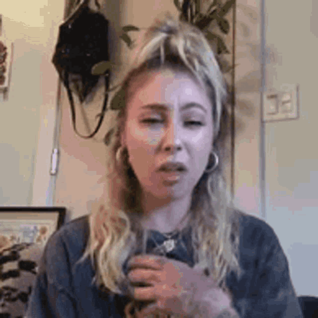 a woman is making a funny face while sitting on a couch in a room .