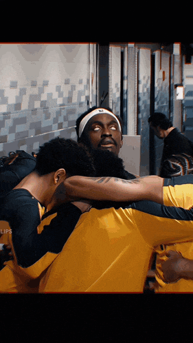 a man wearing a headband with nike on it is hugging another man in a huddle