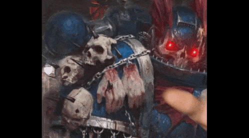 a person is pointing at a painting of a space marine with skulls and chains .