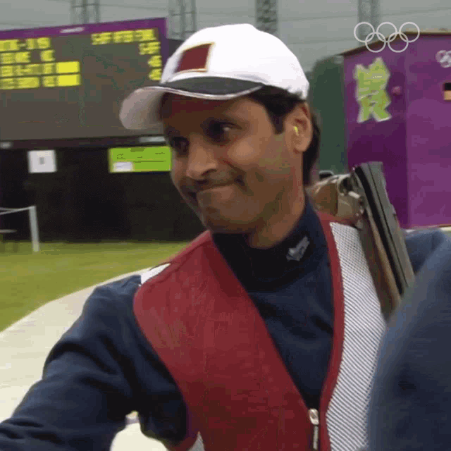 a man wearing a white hat and a red vest is smiling