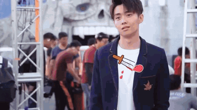 a young man wearing a jacket and a t-shirt with a dagger on it .