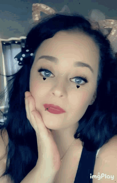a close up of a woman 's face with the word imgplay on the bottom left